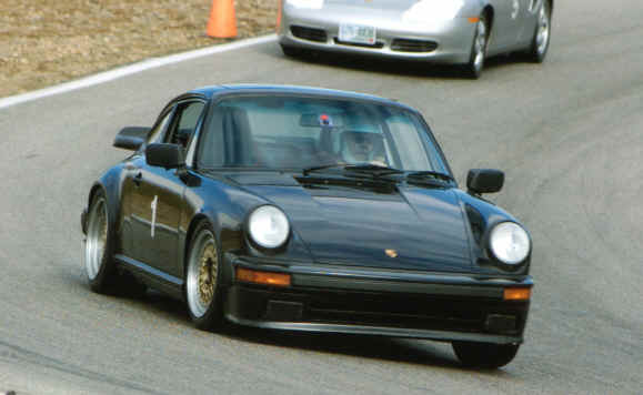 Pete Petersen
Pete's '89 911 has the usual suspension upgrades and safety enhancements appropriate to High Performance Driving.

In this photo Pete is exiting the "Bowl" at NHIS after having passed Edgar Broadhead in his 2000 Boxster S, #5.
